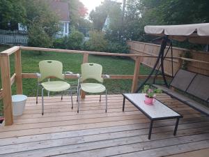a wooden deck with four chairs and a table at Peaceful in Moncton