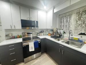 a kitchen with a sink and a stove top oven at Peaceful in Moncton