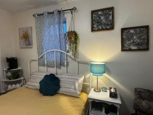 a bedroom with a bed with a blue lamp and a window at Peaceful in Moncton