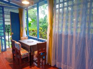ein Tisch und Stühle in einem Zimmer mit Fenster in der Unterkunft Casa MarMaria in Puerto Viejo