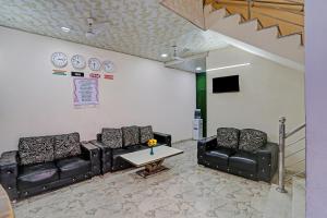a waiting room with two leather couches and a table at Hotel O Raas Near Hira Sweet in New Delhi