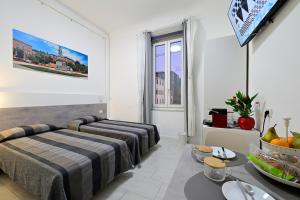 a hotel room with two beds and a table at La Piazza in Ancona