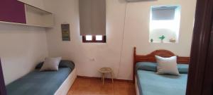 two beds in a small room with a window at La Virgen del Mar in Las Hortichuelas Bajas