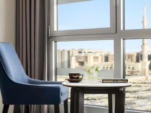 a room with a blue chair and a table and a window at Anwar Al Madinah Mövenpick in Medina +89 photos