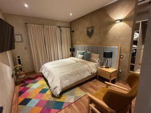 a bedroom with a bed and a chair at Grecia en ValQuirico in Santeagueda
