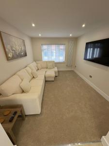 a living room with a white couch and a flat screen tv at Santíago Retreat in Wenvoe