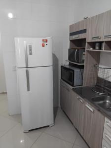 a kitchen with a white refrigerator and a microwave at 502 edificio premieri in Piratuba