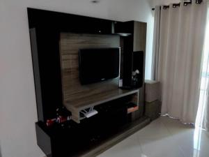 a living room with a flat screen tv on a wall at 502 edificio premieri in Piratuba
