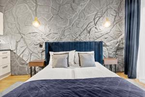 a bedroom with a bed with a stone wall at U1 Metro Nearby - 1-BR - fast Wi-Fi in Vienna