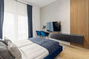 a bedroom with a tv and a bed with two blue chairs at U1 Metro Nearby - 1-BR - fast Wi-Fi in Vienna +21 photos