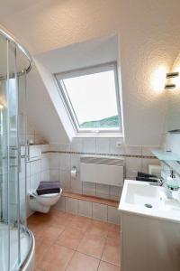 a bathroom with a window and a toilet and a sink at Apartment Alexandra by Interhome in Wintrich