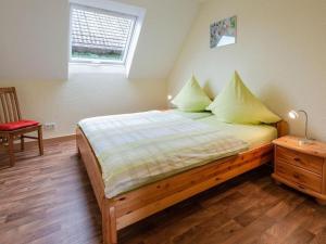 a bedroom with a bed with yellow pillows and a window at Apartment Alexandra by Interhome in Wintrich