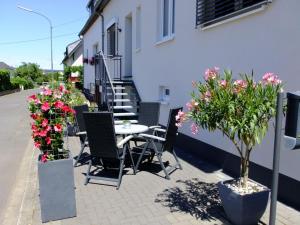 a patio with a table and chairs and flowers at Apartment Alexandra by Interhome in Wintrich +11 photos