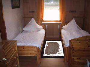 two beds in a small room with a window at Apartment mit Pool und überdachtem Balkon by Interhome in Beerfelden