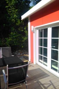 a sliding glass door on a deck with a table and chairs at Holiday Home Tiny Haus Westerwald by Interhome in Bad Marienberg