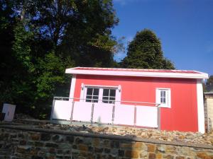 a red and white house on top of a stone wall at Holiday Home Tiny Haus Westerwald by Interhome in Bad Marienberg
