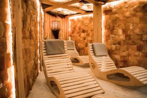 a row of lounge chairs in a room with a stone wall at Willa Pastel in Białystok