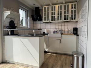 a kitchen with white cabinets and wooden floors at Holiday Home Feriendorf E44 by Interhome in Husen
