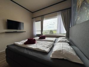 a bedroom with a bed with two pillows on it at Holiday Home Feriendorf E44 by Interhome in Husen
