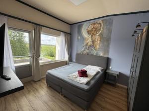 a bedroom with a bed and a painting on the wall at Holiday Home Feriendorf E44 by Interhome in Husen