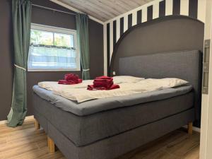 a bed with two red pillows on top of it at Holiday Home Feriendorf E44 by Interhome in Husen