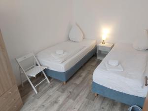 a small bedroom with two beds and a chair at Holiday Home L by Interhome in Kövenig +10 photos