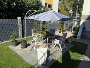 a patio with an umbrella and a table and chairs at Apartment Lahn-Paradies by Interhome in Aull