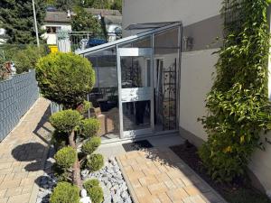 a glass entrance to a house with bushes at Apartment Lahn-Paradies by Interhome in Aull +27 photos