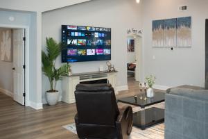 a living room with a television on a wall at DFW Spacious Cozy Modern Villa in Grand Prairie
