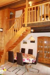 a dining room with a table and a wooden staircase at Holiday Home Marx by Interhome in Bremke