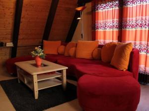 a living room with a red couch and a table at Holiday Home Kirschblüte by Interhome in Ronshausen