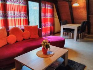 a living room with a red couch and a table at Holiday Home Kirschblüte by Interhome in Ronshausen