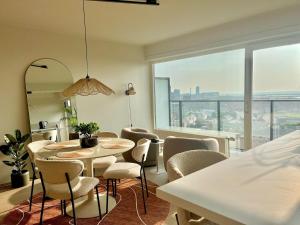 a dining room with tables and chairs and a large window at Joy at sea in Bredene-aan-Zee