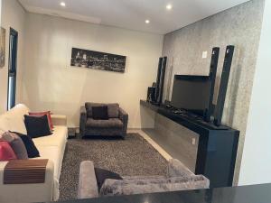 a living room with a couch and a flat screen tv at Casa represa Piracaia in Piracaia