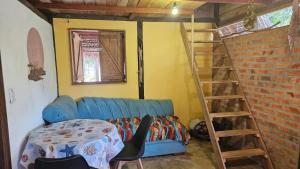 a living room with a blue couch and a ladder at Florada in Ilha do Maiandeua