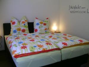 a large white bed with colorful sheets and pillows at Apartment Kommerswag by Interhome in Pittenbach +50 photos