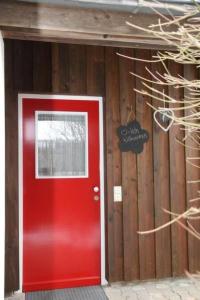 a red door in front of a wooden building at Holiday Home Adele - Allergiker geeignet by Interhome in Zandt