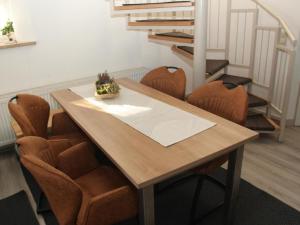 a dining room table with brown chairs and stairs at Holiday Home Adele - Allergiker geeignet by Interhome in Zandt