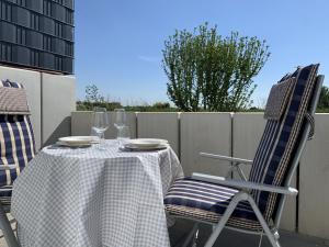 a table with two chairs and two wine glasses at Apartment Feldblick by Interhome in Hartheim