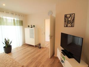 a living room with a large flat screen tv at Apartment Feldblick by Interhome in Hartheim +8 photos