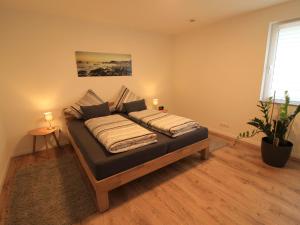 a bed in a bedroom with two lamps and a plant at Apartment Feldblick by Interhome in Hartheim