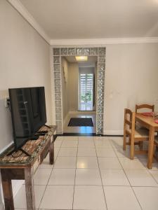 a living room with a tv and a table at Loft 150m da praia in Itajaí