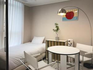 a room with a bed and a table and chair at 2BR City Hall Station 6min, Myeongdong & Namsan Stay in Seoul