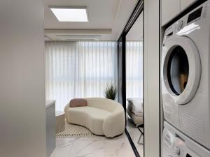 a living room with a chair and a washing machine at 2BR City Hall Station 6min, Myeongdong & Namsan Stay in Seoul