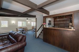 a living room with a leather couch and a bar at Hideaway Mountain Lodge in Fraser