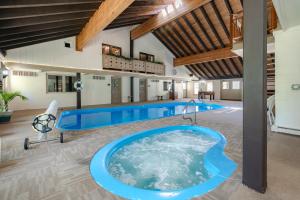 a large indoor pool with a hot tub in a building at Hideaway Mountain Lodge in Fraser