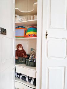 a closet with a stuffed monkey sitting on a shelf at FEWOCASA Central Family Apartment Rorschach - Lake Constance - Near St Gallen in Rorschach +50 photos