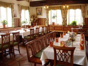 a dining room with tables and chairs and windows at Gasthaus Marienhof in Kirchdorf am Inn