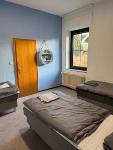 a room with two beds and a door and a window at Bettina City Flat - Ground Floor in Werne an der Lippe