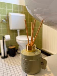 a bathroom with a toilet and a container with sticks at Bettina City Flat - Ground Floor in Werne an der Lippe